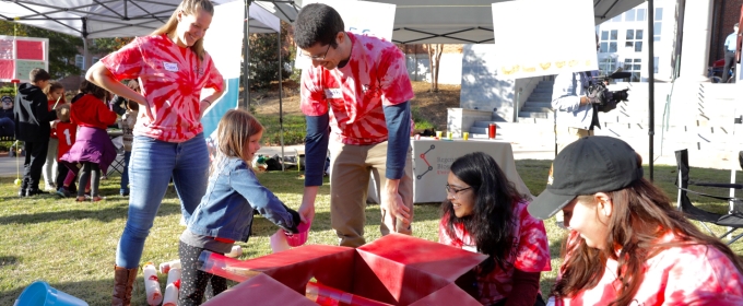 photo of people with child, outdoors with tents