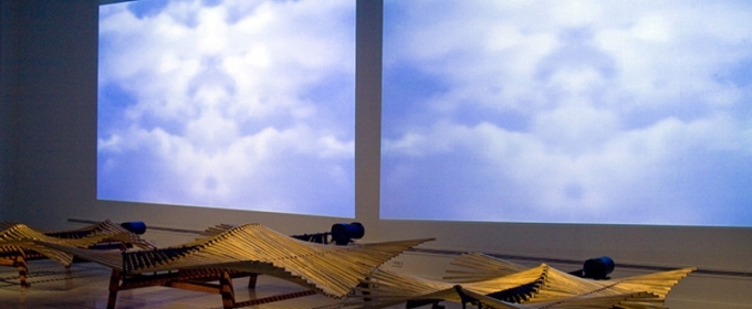 photo of gallery installation with squares of sky and clouds, wood and steel sculptures