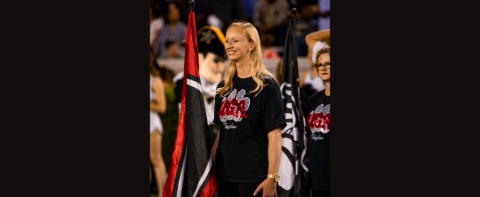 photo of woman on field, with flag