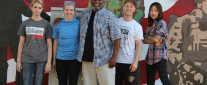 people standing in front of a painted mural