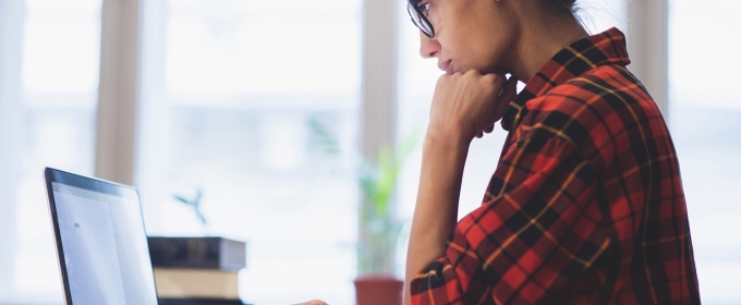 photo of woman standing with laptop computer