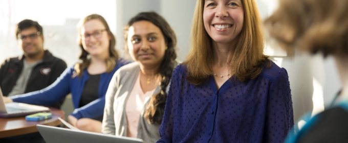 photo of four people, woman in purple in foreground