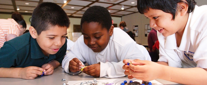 photo of three boys working together in classroom