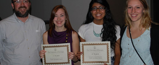 four people, two with certificates, photo