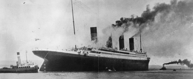 black and white photo of ship and tugs