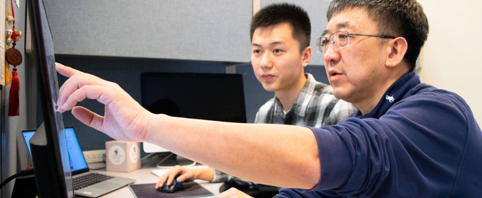 photo of two men at a computer screen